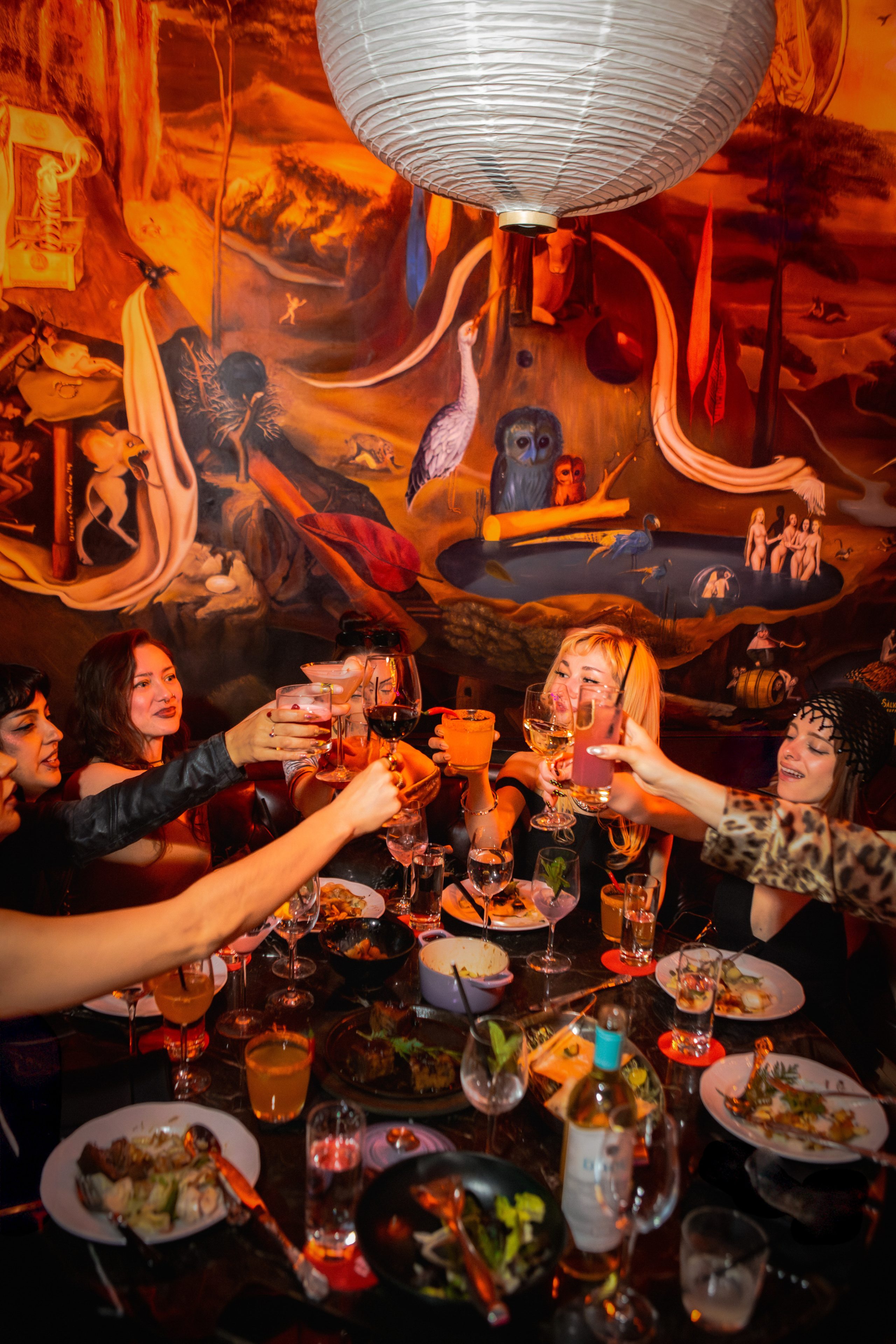 a group of patrons eating dinner and toasting at Paradise Club NYC