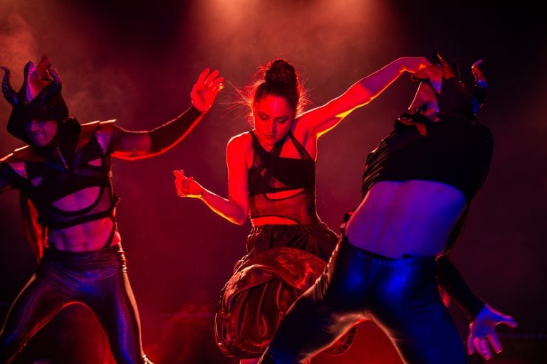 Three dancers in demon costumes perform