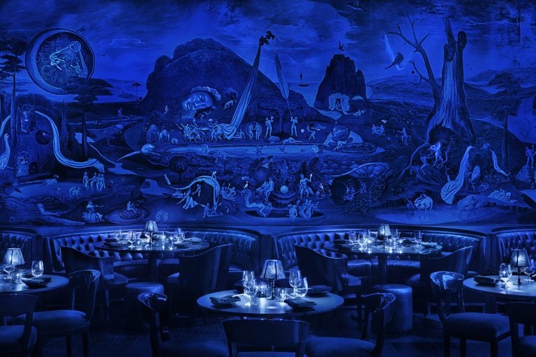 A sitting area at the Paradise Club bathed in blue light