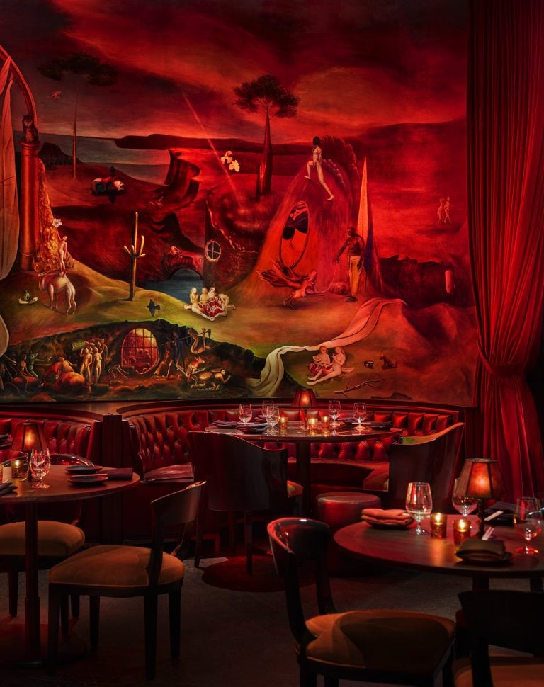 Booths and cabaret tables adjacent to a large mural